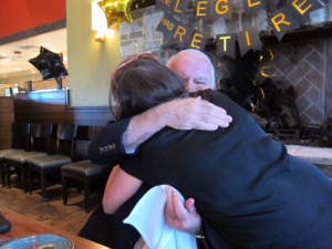 Carolyn and Allen hug at Allen's retirement party